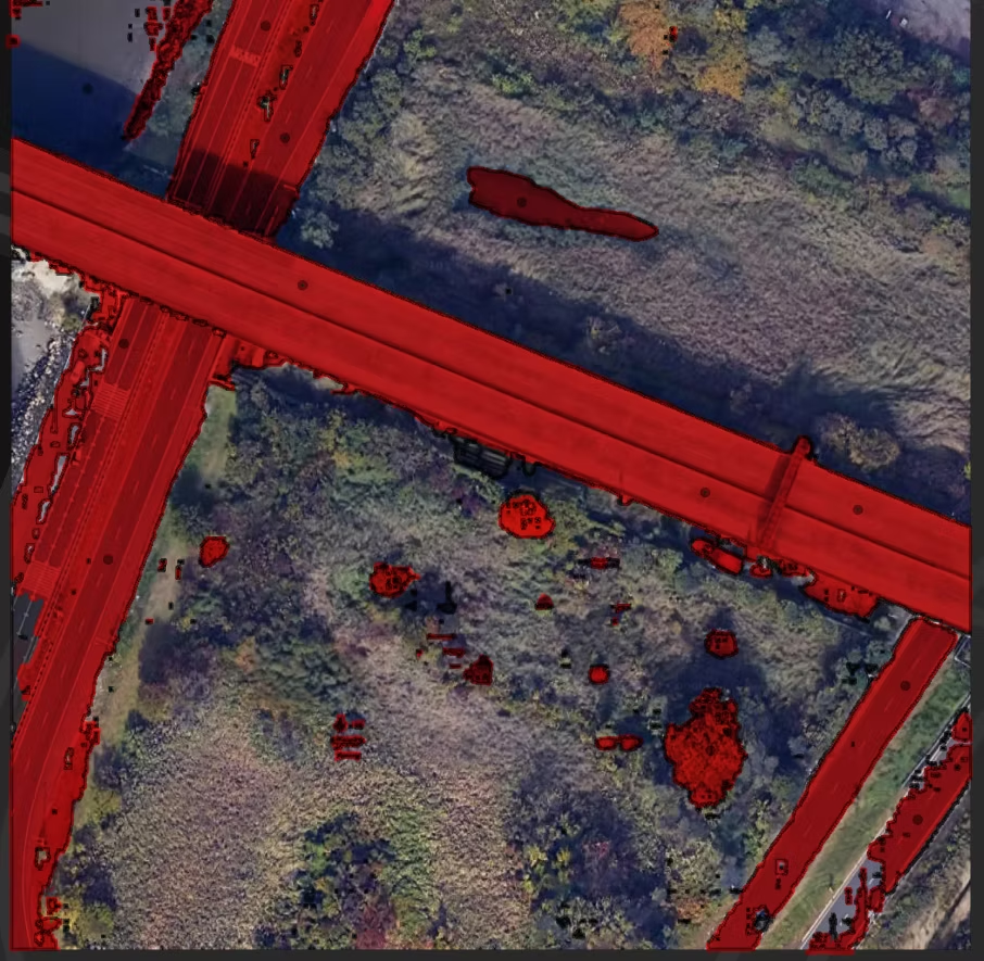 HQ-SAM road segmentation on a satellite image, with the red overlay incorrectly extending onto surrounding vegetation patches